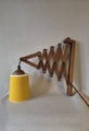 Vintage wooden scissor wall lamp with downward-facing shade.