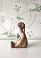 Vintage ceramic figurine holding a small vase for a single flower