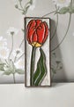Vintage ceramic wall tile with red flower relief on white background