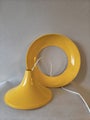 Yellow vintage ceiling lamp with wide plastic dome and low rounded shape.