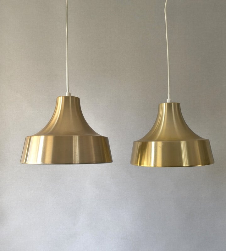 Two gold vintage pendant lamps with conical shape and polished metal surface