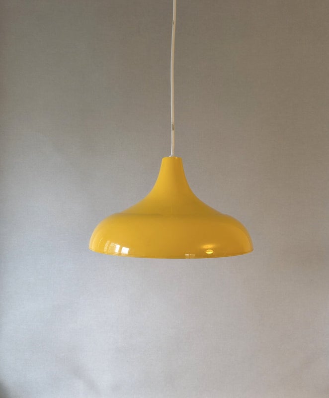 Yellow vintage ceiling lamp with wide plastic dome and low rounded shape.